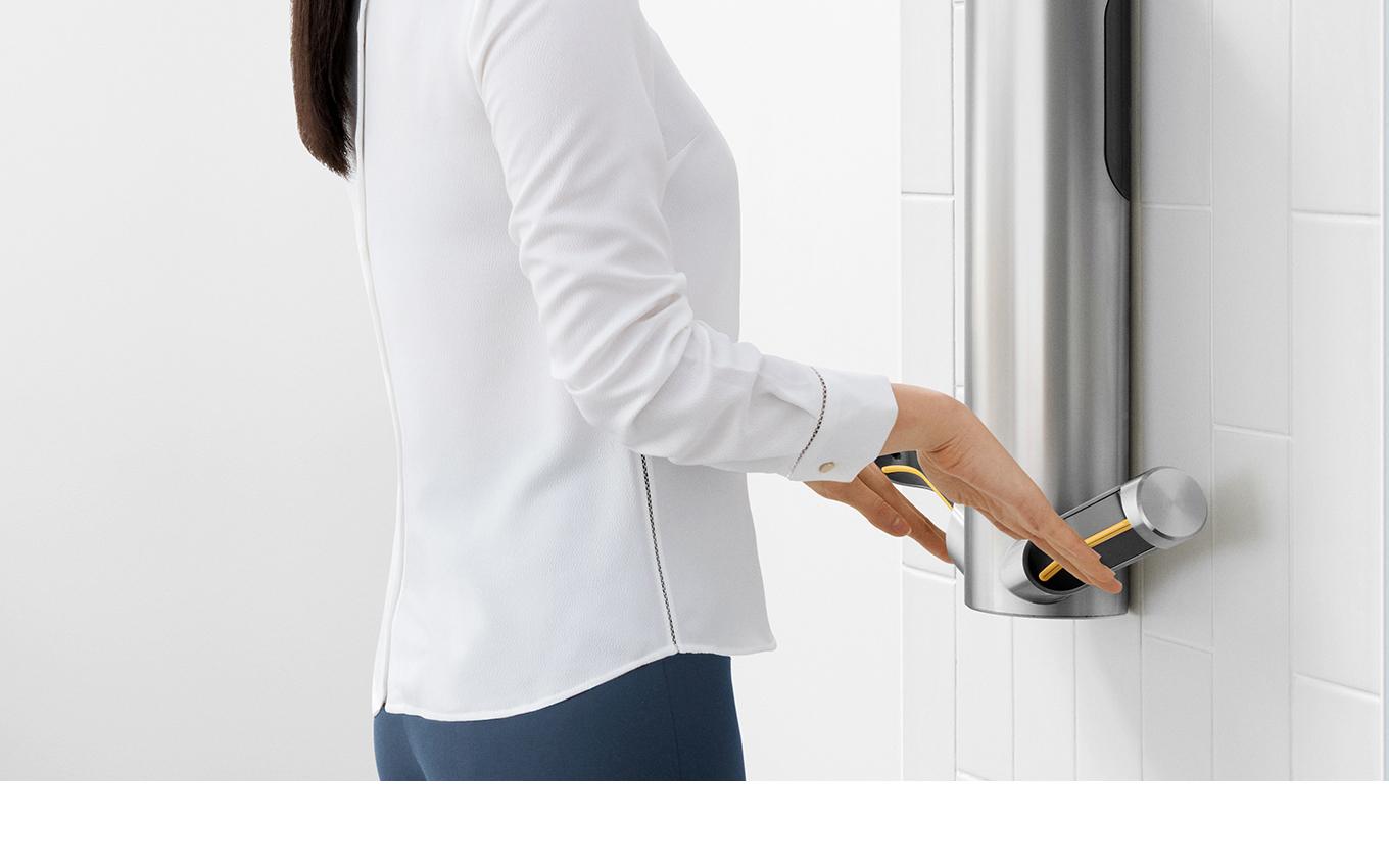 Drying hands underneath Dyson Airblade™ 9kJ hand dryer